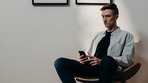 Uomo che guarda preoccupato il suo cellulare- aumento dei prezzi Uomo che guarda preoccupato il suo cellulare- aumento dei prezzi