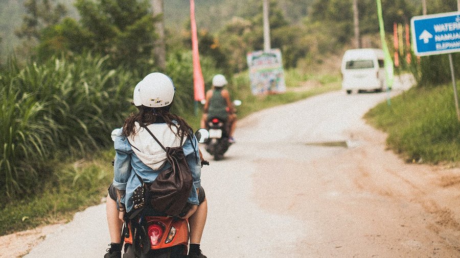 Giovane donna su scooter - backpacking all’estero