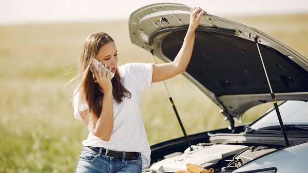 Donna con auto in panne a lato della strada