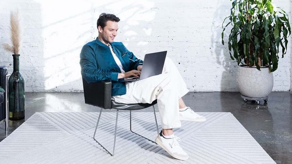 Giovane uomo lavora col computer alla pianificazione del suo budget.