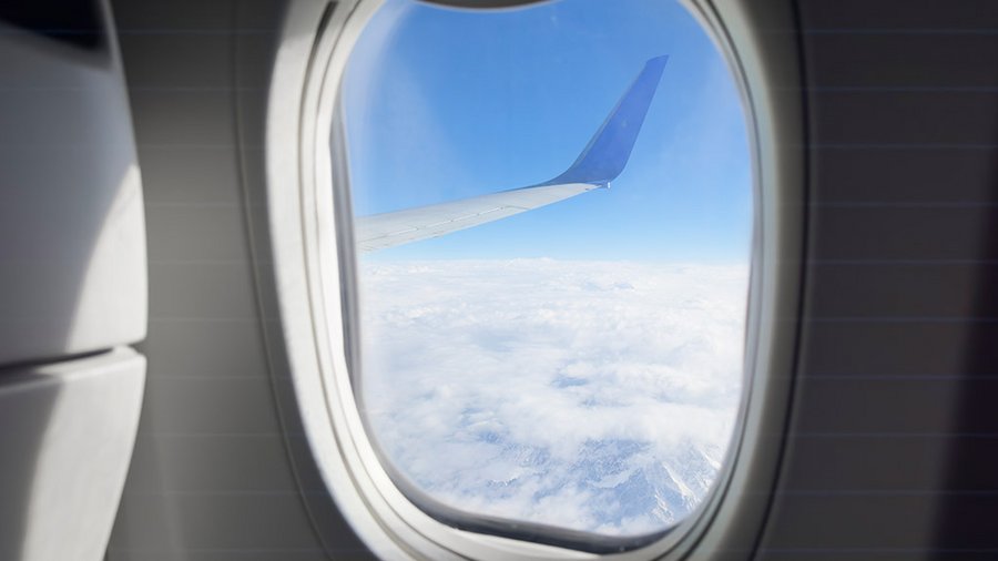 assicurazione viaggio lunga durata per chi parte per un soggiorno prolungato all'estero Orizzonte oltre il finestrino dell'aereo