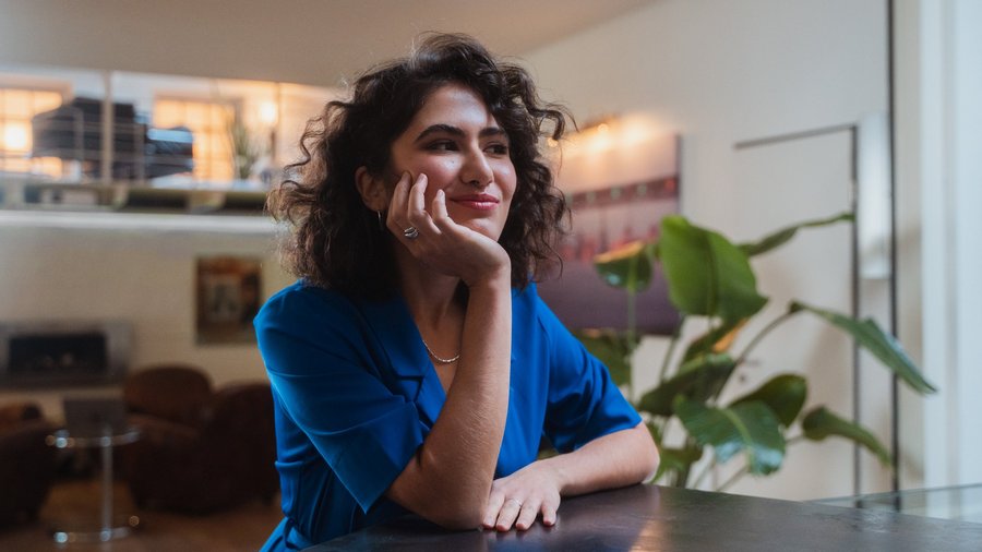 Ragazza vestita di blu che pensa sorridente