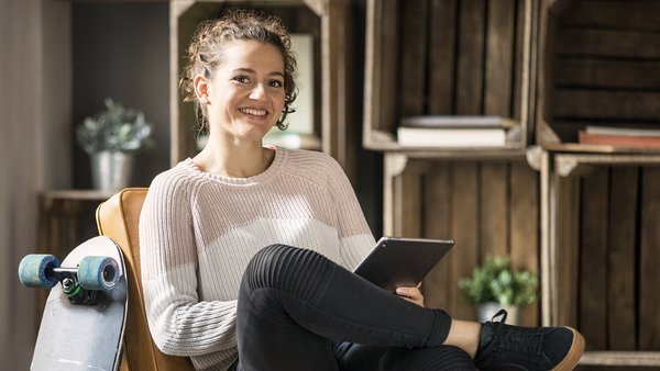 Giovane donna compila un quaderno dei conti su tablet